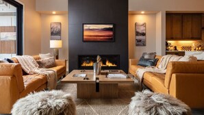 A modern living room with leather sofas, a fireplace, and artwork on the walls. - Summit + Sky (Bozeman)