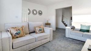 A living room with two sofas, a coffee table, and a staircase leading to another level. - Family two Bedroom Home Free Parking and Backyard (Howden-le-Wear)