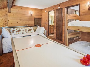 A wooden cabin with a bunk bed, a small table, and a mirror. - Rustic Retreat by Tahoe Getaways - 3 BR Dog Friendly in Tahoe Donner w/ HOA Beach, Gym, Pool (Truckee)