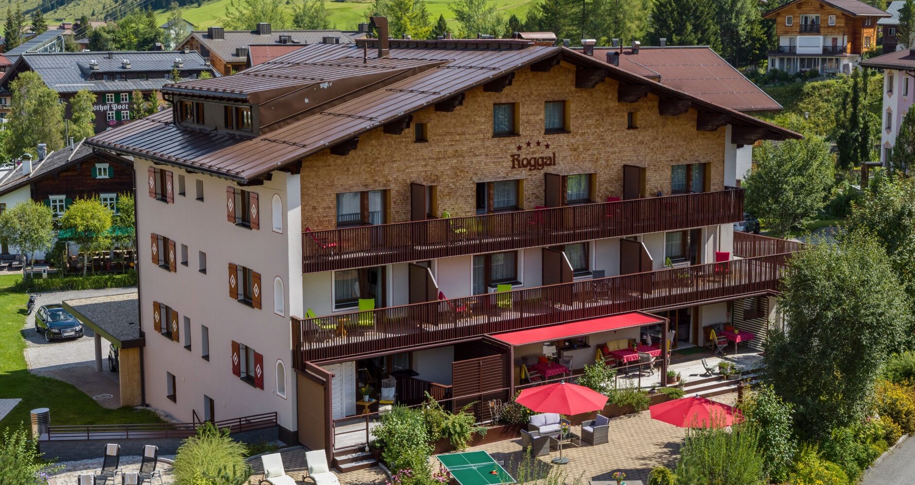 Een meerhoog gebouw met een balkon, terras en een zichtbaar restaurantschild.