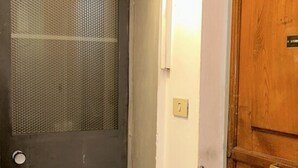 A door with a metal mesh screen and a wooden door next to it.