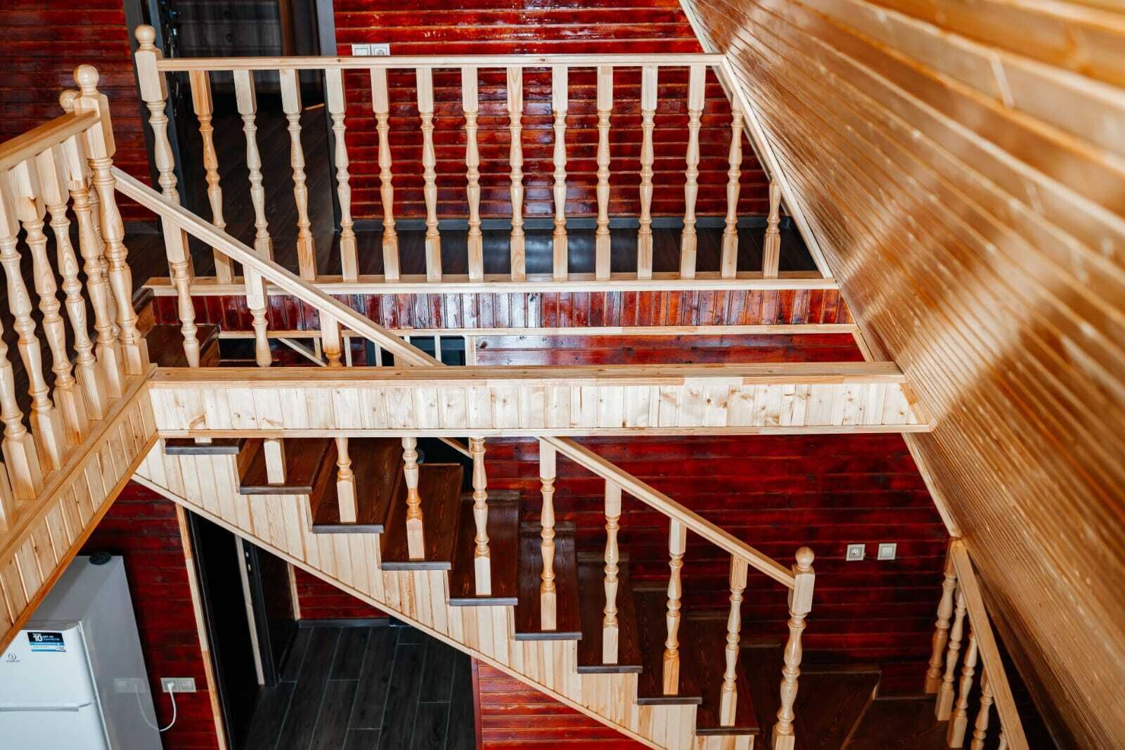 A wooden staircase with a red wall background.