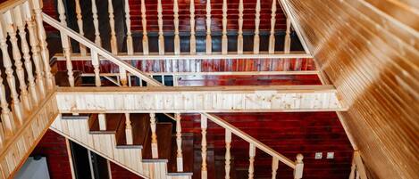 A wooden staircase with a red wall background.