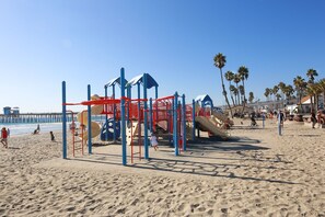 A beach playground with slides and climbing structures.
