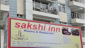 Een bordje voor Sakshi Inn, dat het een hotel met kamers en restaurant aangeeft.