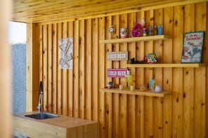 A wooden interior with a sink, shelves with various items, and signs indicating 'COLD BEER'. - WaterWheel Villa by Fidalsa (Almoradí)