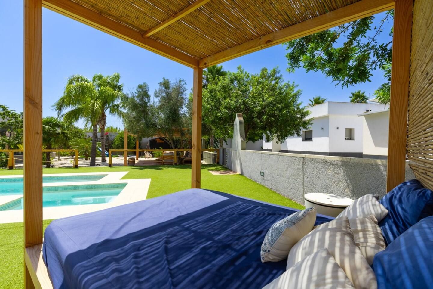 A bedroom with a view of a swimming pool and a garden.