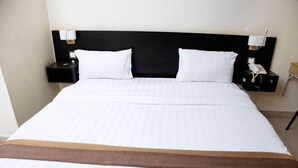 A hotel room with a large bed, two bedside tables with lamps, and a telephone. - UBUNTU PALANCE HOTEL BY RUNATI (Kampala)