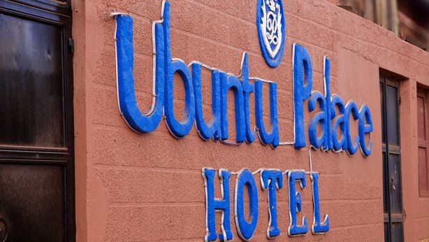 A sign for Ubuntu Palace Hotel with a prominent logo and the word "HOTEL" in large blue letters. - UBUNTU PALANCE HOTEL BY RUNATI (Kampala)
