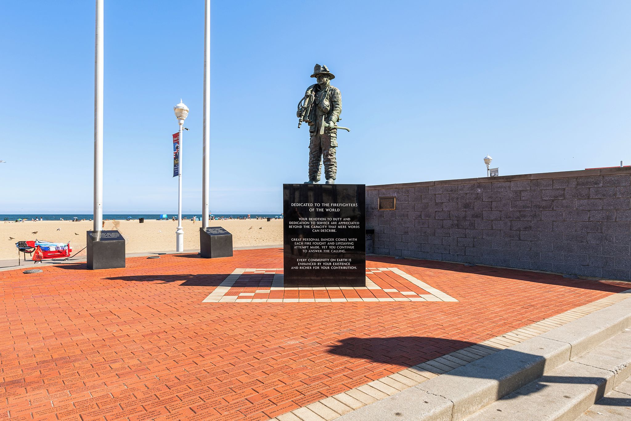 Ein Denkmal mit einer Statue, einer Gedenktafel und einem Pflasterweg.