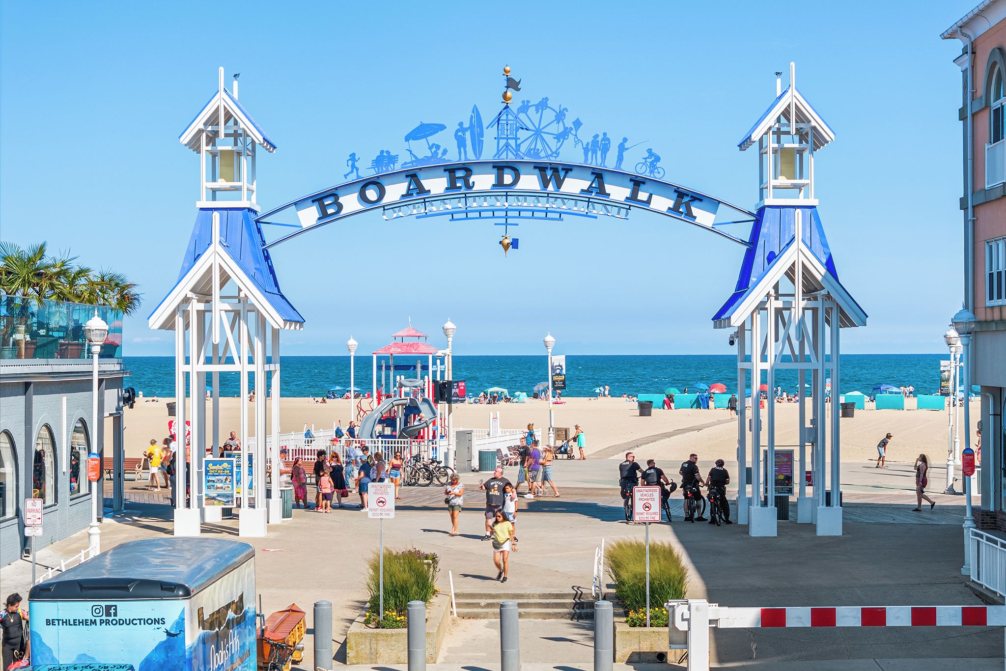 A beach entrance with a sign reading 'BOARDWALK' and a blue archway.