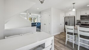 A modern kitchen with white cabinetry, a stainless steel refrigerator, and a built-in oven. - Bayside Bliss 205, Newly Constructed single family house in Uptown Ocean City (Ocean City)