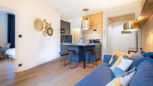 Moderni huoneisto, jossa on keittiö, ruokailutila ja olohuone.
