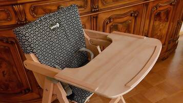 Une chaise en bois avec un coussin à motifs et un plateau de couleur claire.