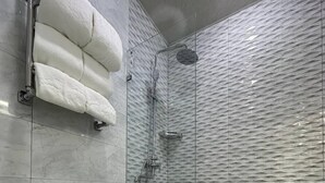 A modern bathroom with a toilet, a glass shower enclosure, and a towel rack. - Hotel Panorama Samarkand (Samarkand)