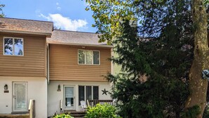 A two-story residential building with a front porch and a pathway leading to the entrance. - Dog-Friendly 3BR Townhome with All Seasons Room – Bayberry Woods (Bethany Beach)