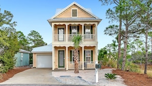 A two-story house with a front porch, a garage, and a well-maintained lawn. - Beach Haven-Spacious 3BR-3BA Pet Friendly (Gulf Shores)