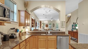 A kitchen with granite countertops, wooden cabinets, a stainless steel dishwasher, and a built-in microwave. - Beach Haven-Spacious 3BR-3BA Pet Friendly (Gulf Shores)