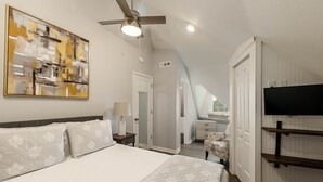 A bedroom with a bed, a ceiling fan, a TV mounted on the wall, and a painting on the wall. - Dynasty Dome 901 - Book for Football Season! (Tuscaloosa)