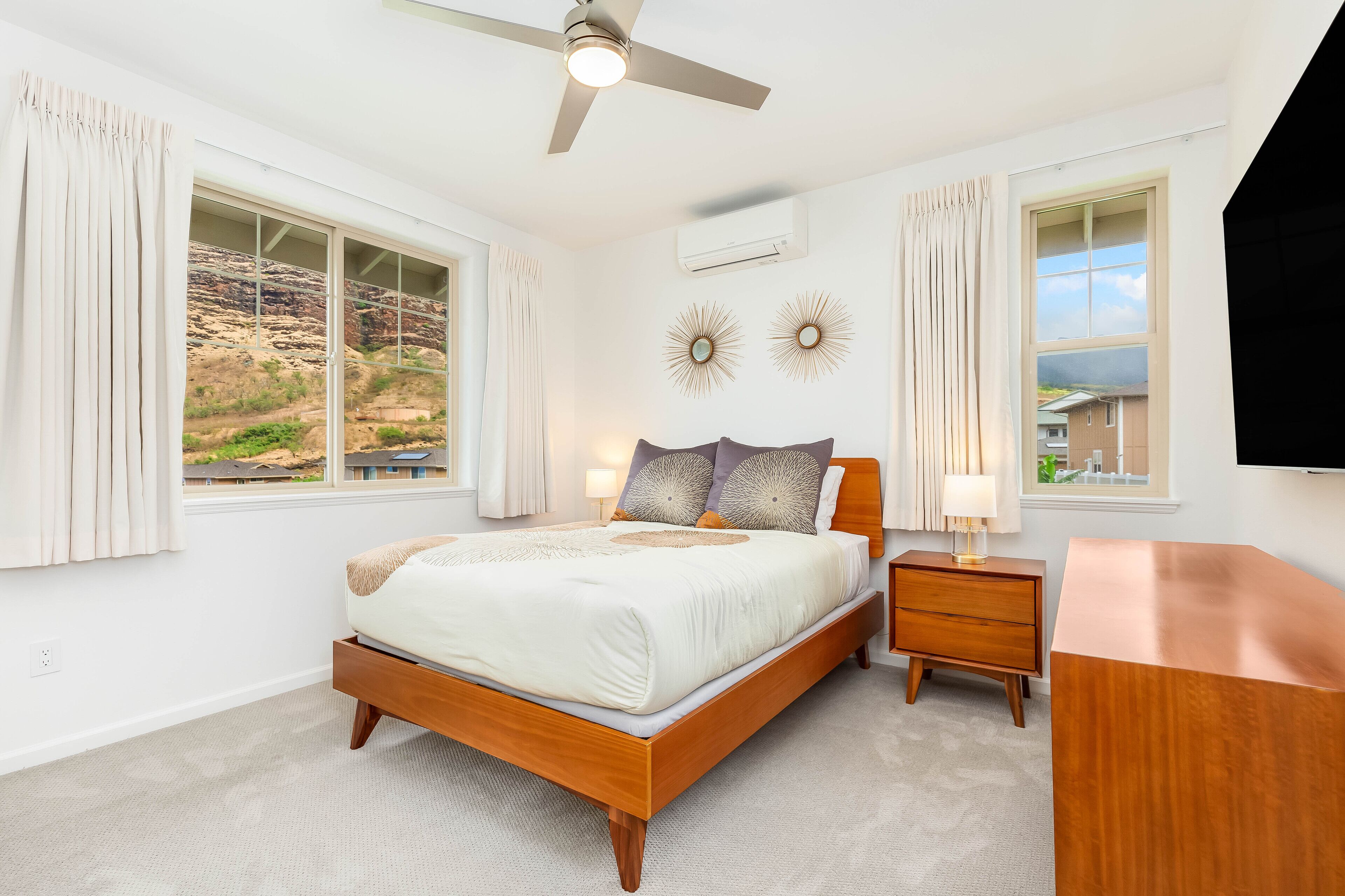 A bedroom with a bed, nightstand, and a TV.