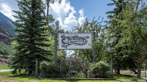 Un panneau d’accueil indiquant le nom du lieu : « OURAY », avec un paysage montagneux en arrière-plan.
