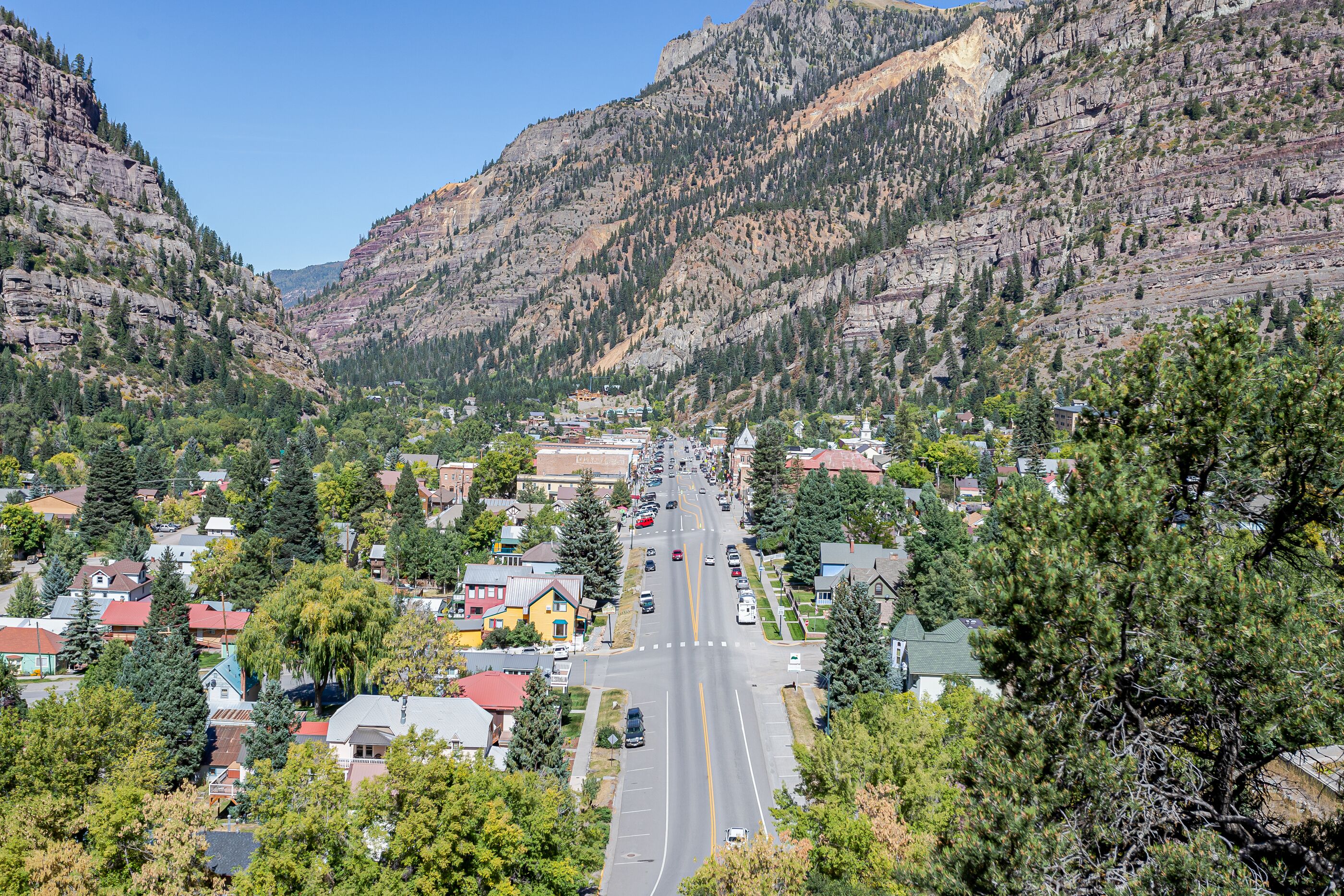 A town nestled between mountains with a main road running through it.