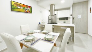 A modern kitchen with white cabinets, a stainless steel range hood, and a built-in oven. - Exclusive 3 Bedrooms - Samaria Beach Club (Santa Marta)
