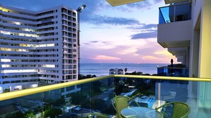 A balcony with a glass railing overlooking a cityscape and a sunset view. - Exclusive 3 Bedrooms - Samaria Beach Club (Santa Marta)
