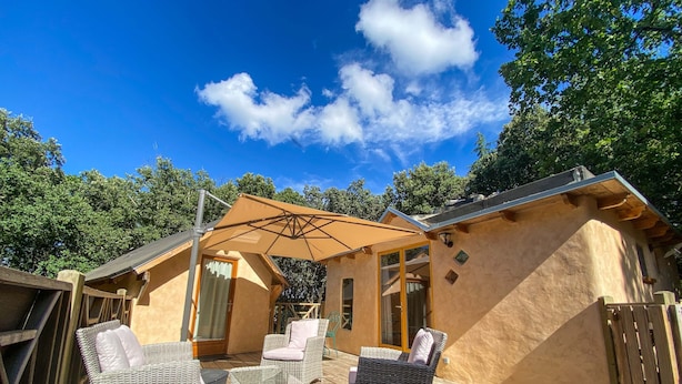 A wooden deck with wicker furniture and a covered patio area. - Cabane "les 3 Complices" (Labastide de Virac)