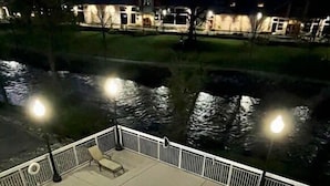 A swimming pool with a white deck and a metal fence. - Riverfront Condo Pigeon Forge (Pigeon Forge)