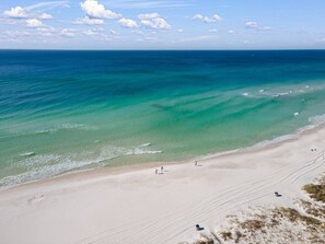 A beach with clear turquoise water and a sandy shore.