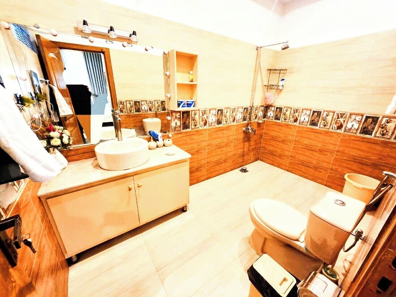 A bathroom with a sink, mirror, toilet, and shower.