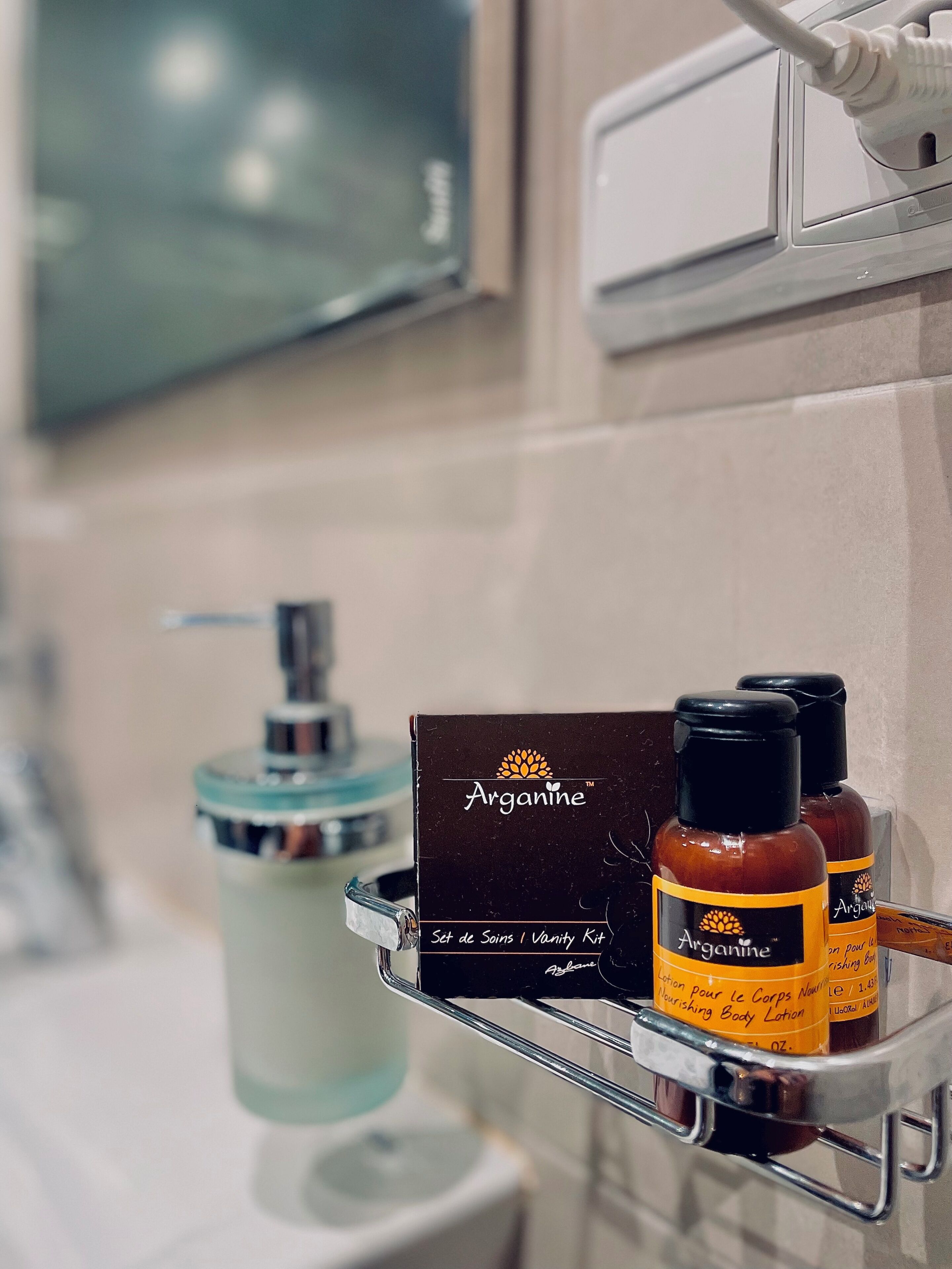 A bathroom shelf with a vanity kit, a bottle of lotion, and a bottle of body lotion.