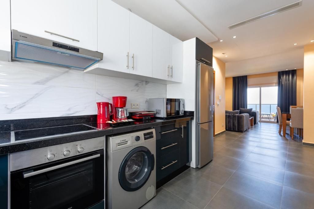 A modern kitchen with a built-in washer and dryer, a microwave, and a refrigerator.