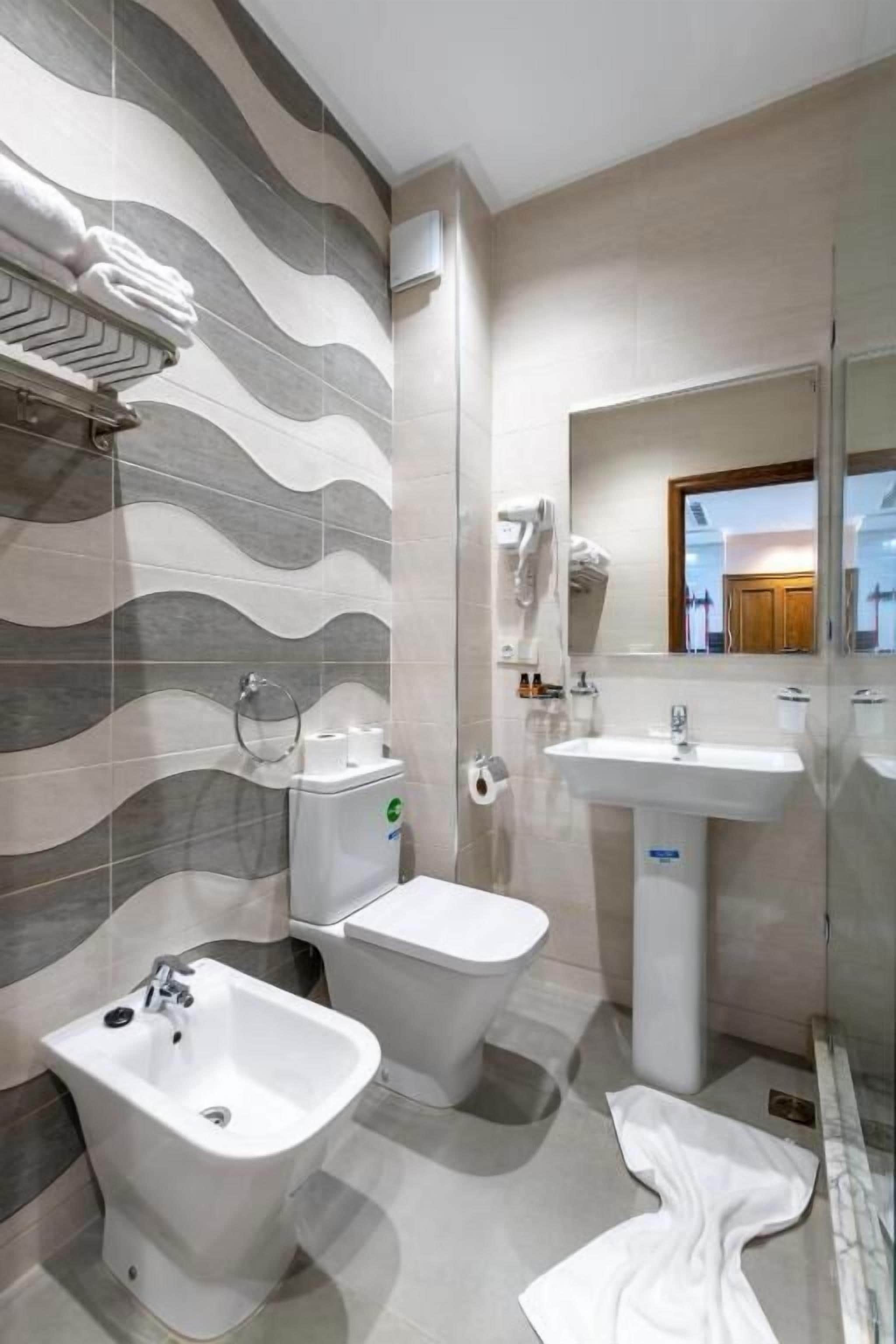 A modern bathroom with a bidet, toilet, and sink.