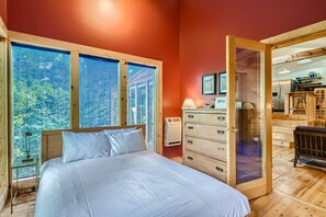 Une chambre à coucher avec un lit, une commode et une fenêtre équipée de stores.