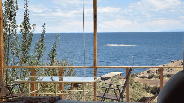 Une chambre avec un lit, une table et une vue sur la mer.