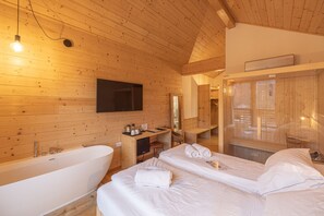 A wooden cabin-style bedroom with a large bed, a bathtub, and a mirror. - B&B GIALLO - Ribes Wellness Room (Pieve di Cadore)