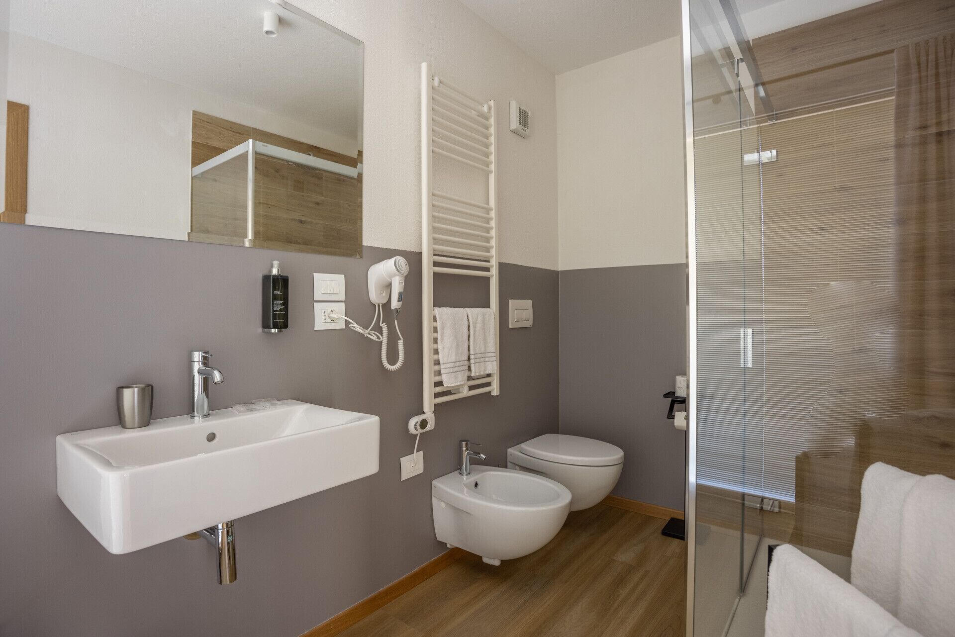 Ein modernes Badezimmer mit Waschbecken, Bidet und Toilette.