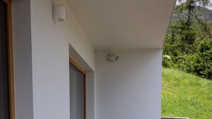 Un balcon doté d’un plancher en bois, de deux chaises et d’une petite table.