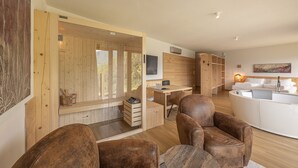 Un intérieur moderne avec un mur en bois, un coin salon avec des fauteuils en cuir marron, un canapé blanc et un bureau en bois.