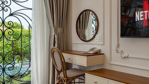 A room with a wooden desk, a chair, a dresser, a TV, and a window with curtains. - Golden Sun Apartment & Hotel (Ho Chi Minh City)
