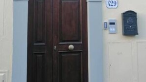 A dark wooden door with a decorative arch above it, a mailbox, and a house number 129. - Romantic Nest Florence Studio (Firenze)