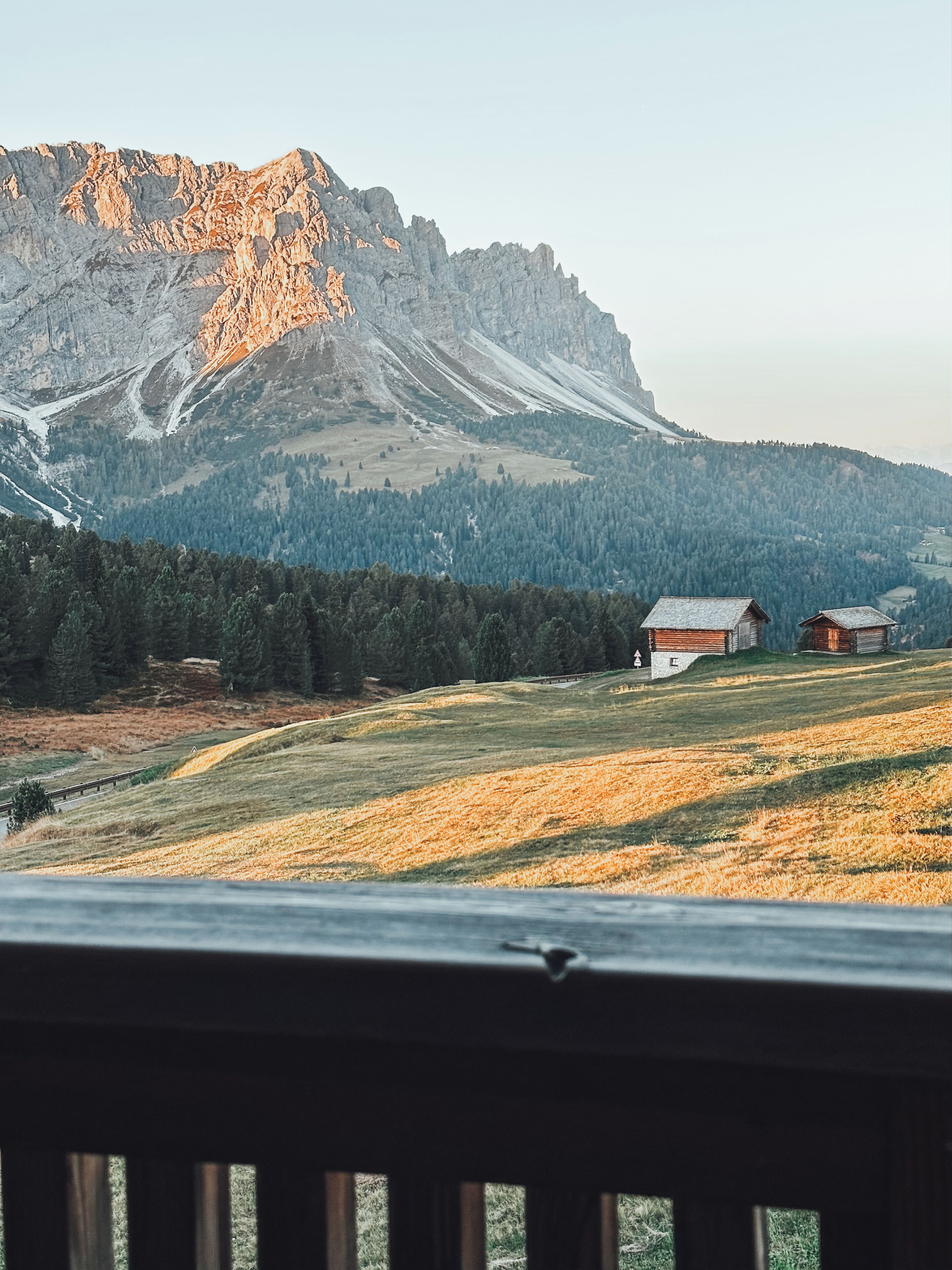 Eine gebirgige Landschaft mit einem hölzernen Deck im Vordergrund.