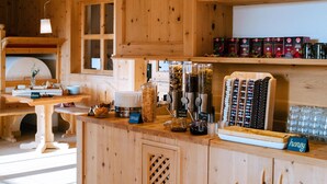 A wooden kitchen with a central island, built-in shelves, and a window. - Ütia de Börz Mountain Lodge (San Martino in Badia)