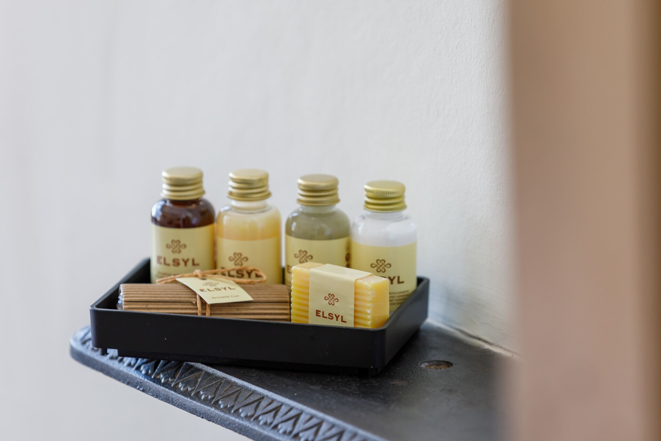 A tray with four bottles and two bars of soap labeled ELSYL.