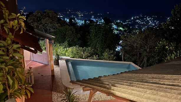A swimming pool with a view of a cityscape at night. - Casa Calamar Zihuatanejo (Gro)