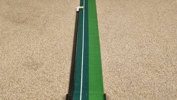 Ein Putting-Green mit Golfschläger und Bällen.