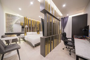 Una habitación de hotel moderna con cama, escritorio, sillas y televisión.