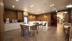 Un moderno vestíbulo de hotel con mostrador de recepción, zona de estar y minibar visible.